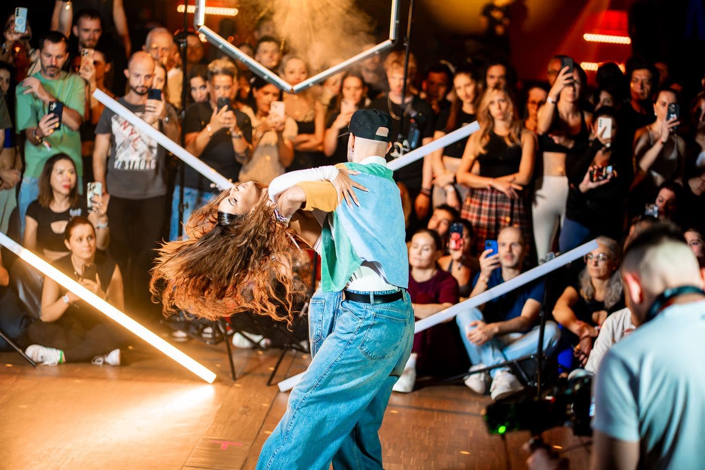 Two artists mid-spin during a workshop demo, students all around